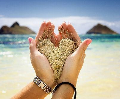un joli coeur de sable dans les mains