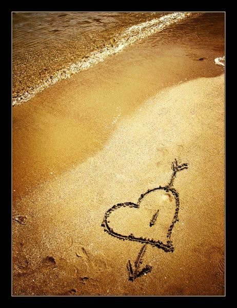 coeur et flèche sur le sable