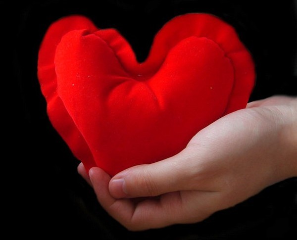 Un coeur rouge dans une main